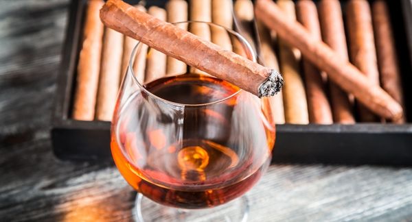 Wedding cigar burning on top of a glass of cognac