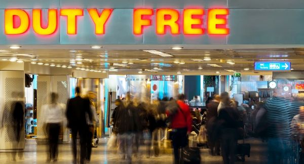 Duty free sign above travelers in busy airport