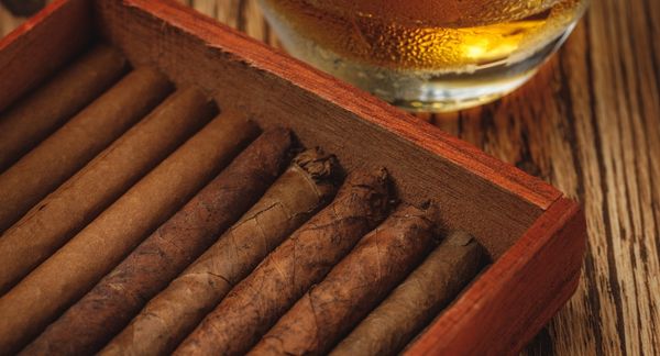 Cigars in Box on Table with Bourbon Glass
