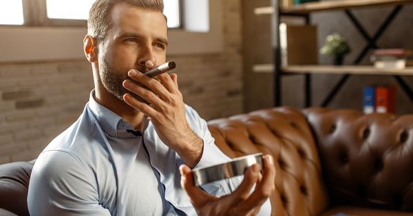 Man smoking cigar on couch